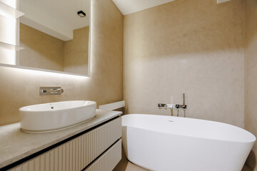 A bathroom that includes a bathtub, a sink, and a wallmounted mirror