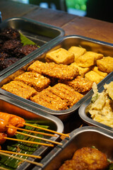 Assorted Side Dishes, Indonesia, captured on May 29, 2025. A variety of traditional Indonesian foods including tempeh, tofu, chicken, eggs, and vegetables served with sambal
