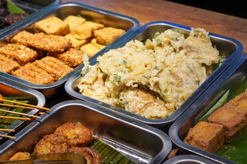 Assorted Side Dishes, Indonesia, captured on May 29, 2025. A variety of traditional Indonesian foods including tempeh, tofu, chicken, eggs, and vegetables served with sambal