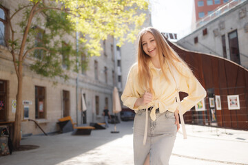 Naklejka premium Young woman enjoying sunny day in urban courtyard with modern architecture