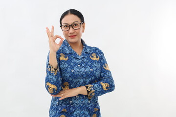 Happy Indonesian civil servant woman standing while showing okay hand gesture