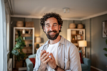 Portrait of smiling freelancer working from home office: happy man with beard and mustache