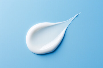 Soft cream drop on a light blue background. Moisturizing rich cream, natural cosmetic concept. Minimalistic photo, advertising.