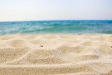 Soft golden sand under a clear blue sky on a hot summer day. Sunny beach sand with empty space for product placement – summer vacation concept. 