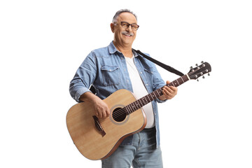 Mature man standing and playing an acoustic guitar