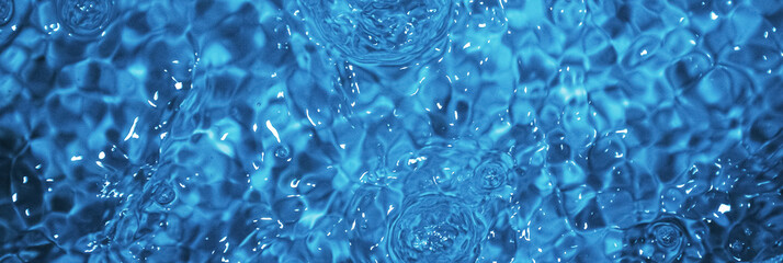 Obraz premium Blue water with ripples. Defocus blurred bleu clear calm water surface texture with splashes and bubbles.