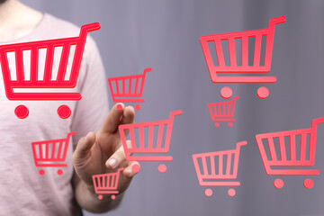 Person interacting with digital shopping carts, symbolizing online shopping and e-commerce.
