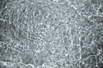 Blue water with ripples. Defocus blurred bleu clear calm water surface texture with splashes and bubbles.