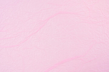 Pink crumpled paper texture as background.
