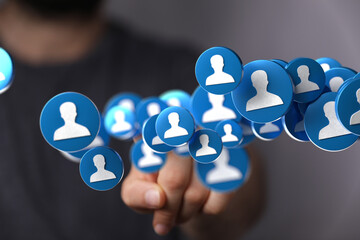 Image depicts a hand interacting with floating profile icons, symbolizing networking, social media,...