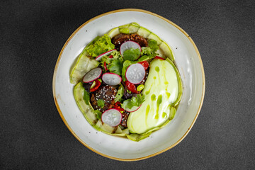 Fresh vegetable salad of green lettuce, radish and cucumber with dill, green onions and greek yogurt