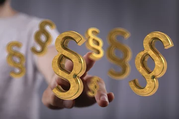 Fotobehang Hand reaching for 3D golden paragraph symbols.  Legal concept. © vegefox.com