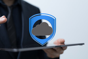 Businessperson holding tablet showing secure cloud data protection.  Cybersecurity concept.
