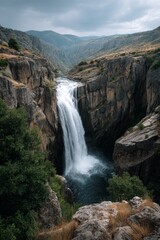 A picturesque mountain river gorge with waterfall cascading through the rocks.