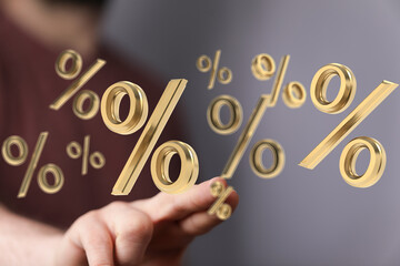 3D rendered image of gold percentage symbols floating above a hand, symbolizing discounts, interest...