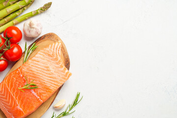 Salmon fillet with fresh vegetables on white background.