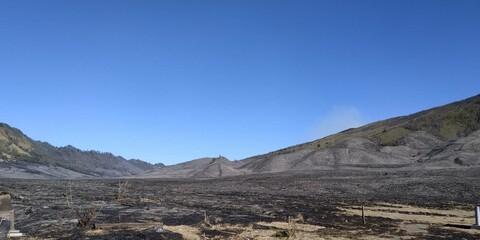 Vast Volcanic Plain with Hills and Clear Sky