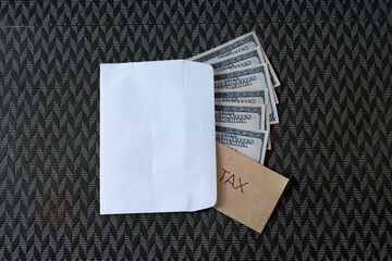 Cash Dollars money in envelope with note written TAX.