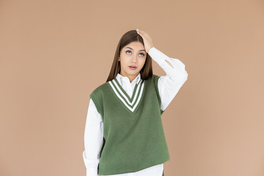 Gosh why me. Portrait of unhappy and annoyed young arrogant woman in green vest facepalming with irritation breathing out with opened mouth and rolling eyes from annoyance