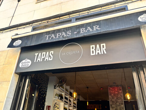 Alicante, Spain - May 29, 2025: Tapas bar entrance showcasing La Crispeta sign, inviting atmosphere with warm lighting and modern decor, perfect for culinary experiences in vibrant city