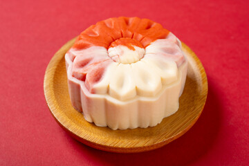 angle view flower shape white and red mooncake on red