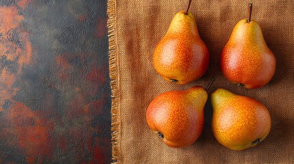 Intricate top view composition featuring fresh ripe pears on vibrant orange burlap with selective focus and ample copy space for design and diet presentation.