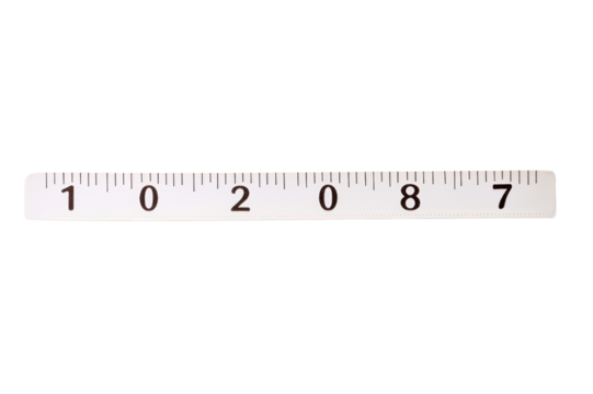 Close-up of a transparent plastic ruler with black measurement markings on a white background for precise length measurement and drawing guides