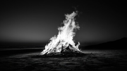 Dramatic Black and White Beach Bonfire at Dusk Creating Enchanting Flames Against a Dark Sky