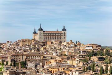 View of Toledo with the Alcazar rising above the city, surrounded by narrow streets and traditional buildings in this historic Spanish imperial town