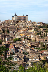 View of Toledo with the Alcazar rising above the city, surrounded by narrow streets and traditional buildings in this historic Spanish imperial town