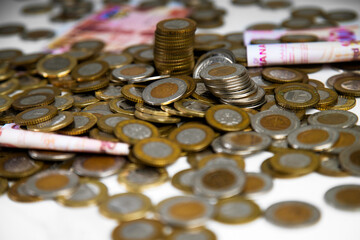 Close up of a lot of Ghanaian cedi coins with few notes spread on desk