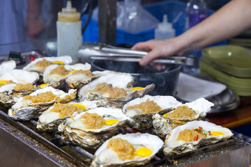 Street food oysters with raw garlic topping