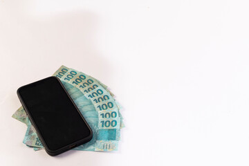 Black Cellphone and Brazilan 100 Reais Banknotes on a white background