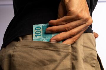 A Man With Brazilian 100 Reais Banknotes on his pocket on white background