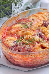 Sweet potato, parsnips and beet root au gratin, in glass dish, vertical