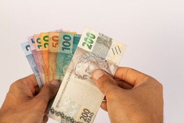 Hands of a Man Holding Brazilian Bank Notes Reais ready to pay