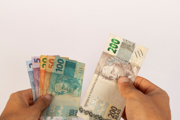 Hands of a Man Holding Brazilian Bank Notes Reais ready to pay