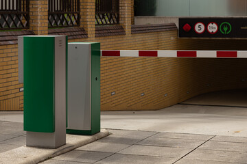 Automatic entry barrier at modern underground parking garage with security system, electric vehicle...