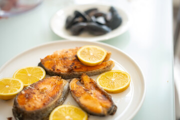 fried salmon fish with lemon plate close up