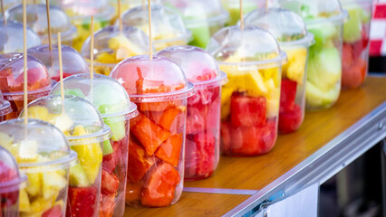 Various pieces of fruit in plastic cups. Healthy food for people.