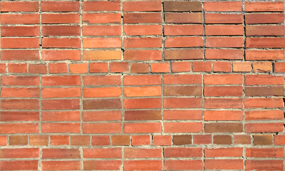 Seamless-looking close-up of an old brick wall made of mostly red and some yellow bricks. Weathered surface with natural imperfections and vintage character. Ideal for use as a repeating background or