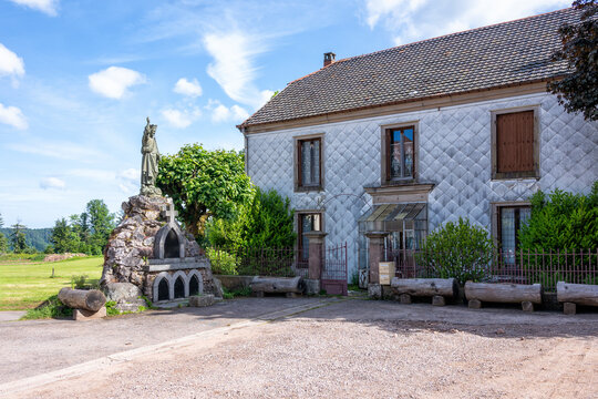 Vieille maison de village dans les Vosges et monument religieux