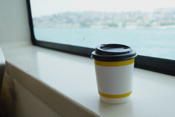 Coffee cup on a windowsill with a waterfront view