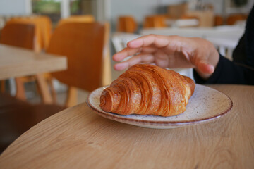 Enjoying a fresh croissant in a cozy cafe setting
