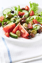 Healthy and tasty salad with , various tomatoes, olives, cucumber, onion and lettuce.	