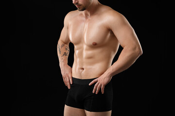 Young man in stylish underwear on black background, closeup