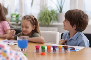 Kids painting at table indoors. Learning to draw