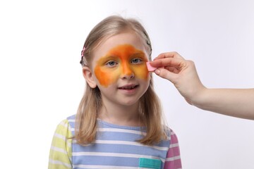 Animator drawing fox on girl's face against white background, closeup