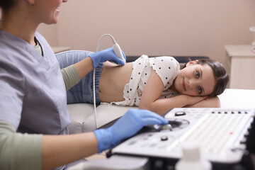 Sonographer conducting girl's renal ultrasound examination in clinic, closeup