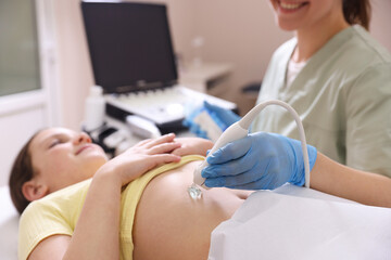 Sonographer conducting girl's abdominal ultrasound examination in clinic, closeup